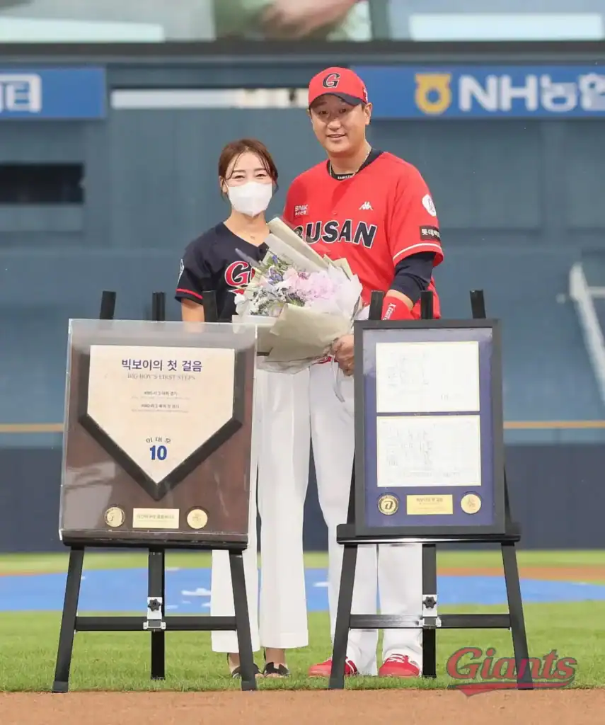 롯데 자이언츠의 이대호 선수가 은퇴식 행사에서 기념패와 꽃다발을 받고 기념촬영을 하는 장면